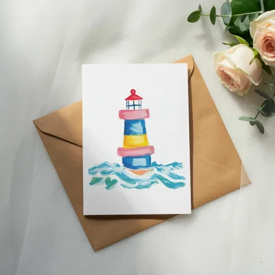Watercolor illustration of a lighthouse on waves, placed on a kraft paper envelope.