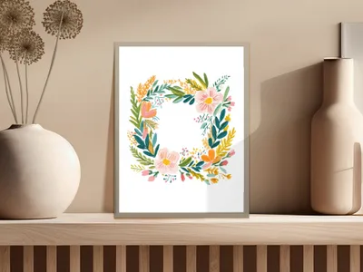 Floral wreath artwork with pink and orange flowers on a shelf.