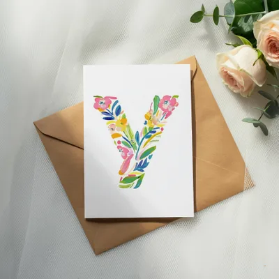 White card with colorful floral letter "Y" on brown envelope.