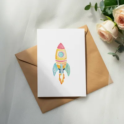 Watercolor rocket card on brown envelope with roses and eucalyptus.