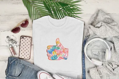 White t-shirt with colorful floral thumbs-up graphic.