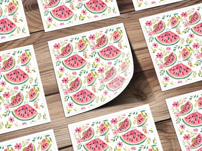 Watermelon slice and flower pattern on square cards arranged on a wooden surface.