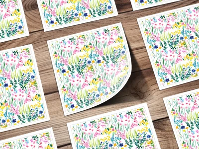 Several cards with a colorful watercolor floral pattern spread across a wooden surface.