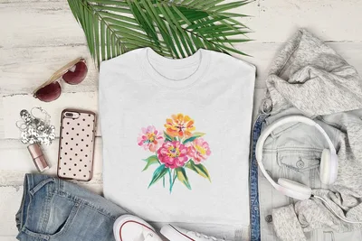 White t-shirt with watercolor floral bouquet design, laid flat with clothing and accessories.