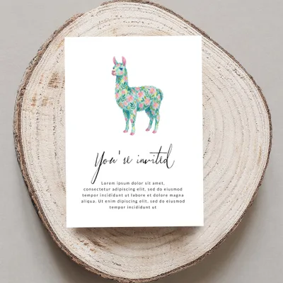 Card with floral llama and "You're invited" text on wood slice.