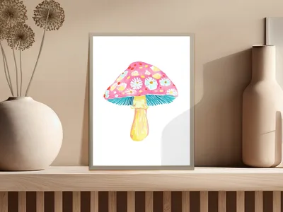 Pink mushroom with floral pattern in a frame on a shelf.