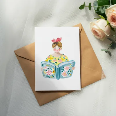 Illustration of a woman reading a book with floral patterns on a greeting card.