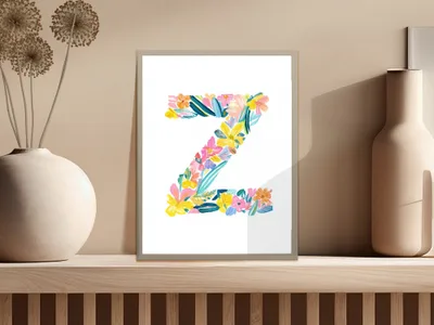 Floral letter "Z" artwork in a white frame on a shelf.